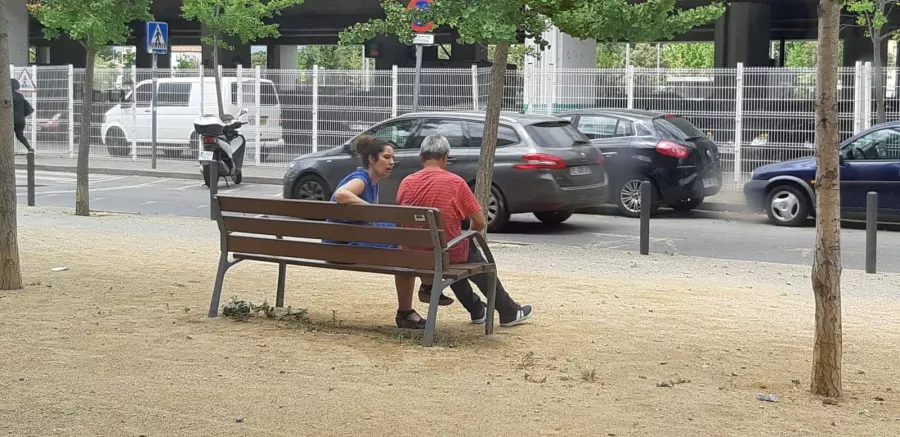 dues persones xerrant assegudes en un banc