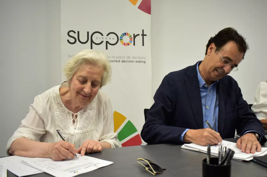 Una dona i un home signant. Són la presidenta de la Fundació Tutelar Fadesia i el president de Support-Girona