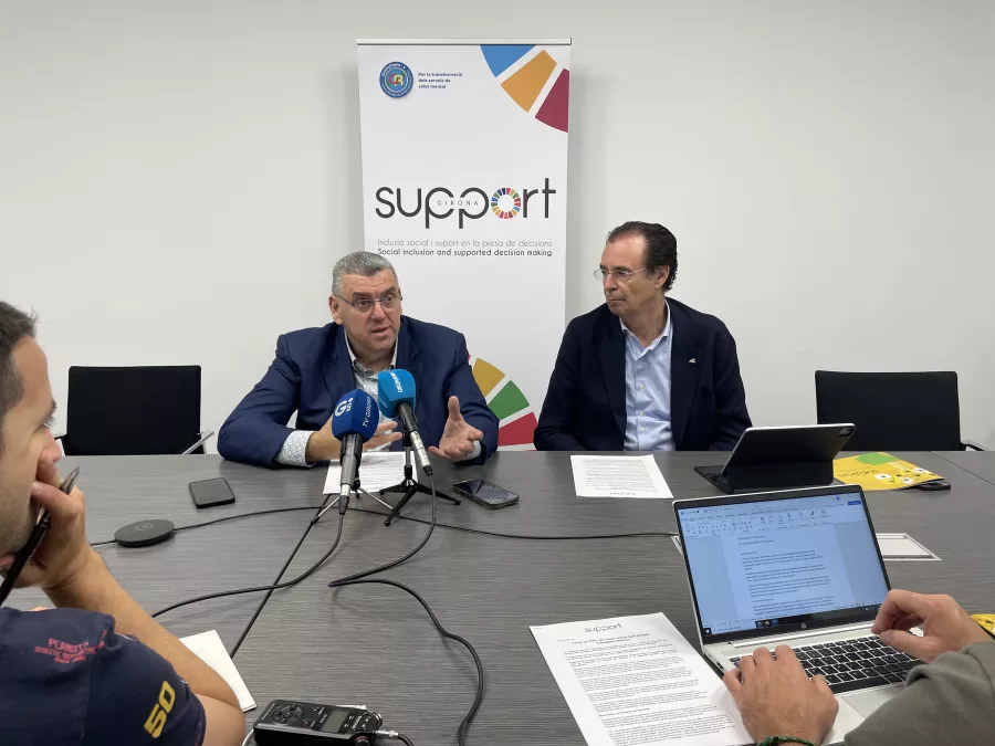 Dues persones davant micros informant en roda de premsa