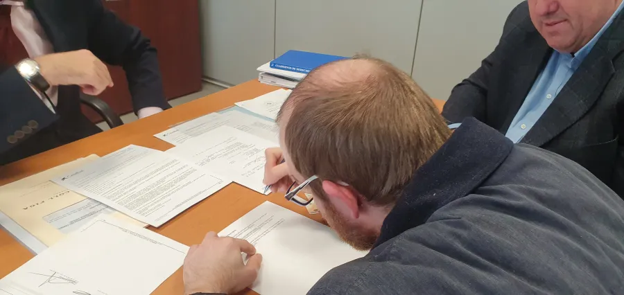Una persona signant un document al notari