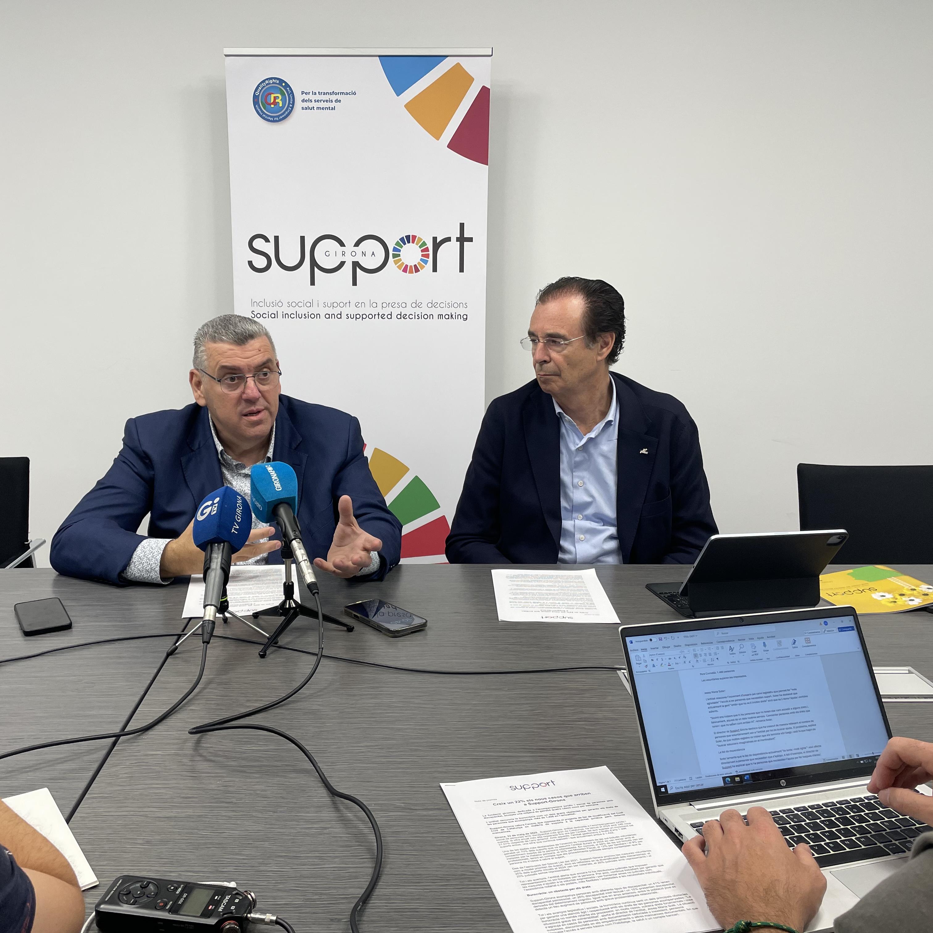 Dues persones davant micros informant en roda de premsa