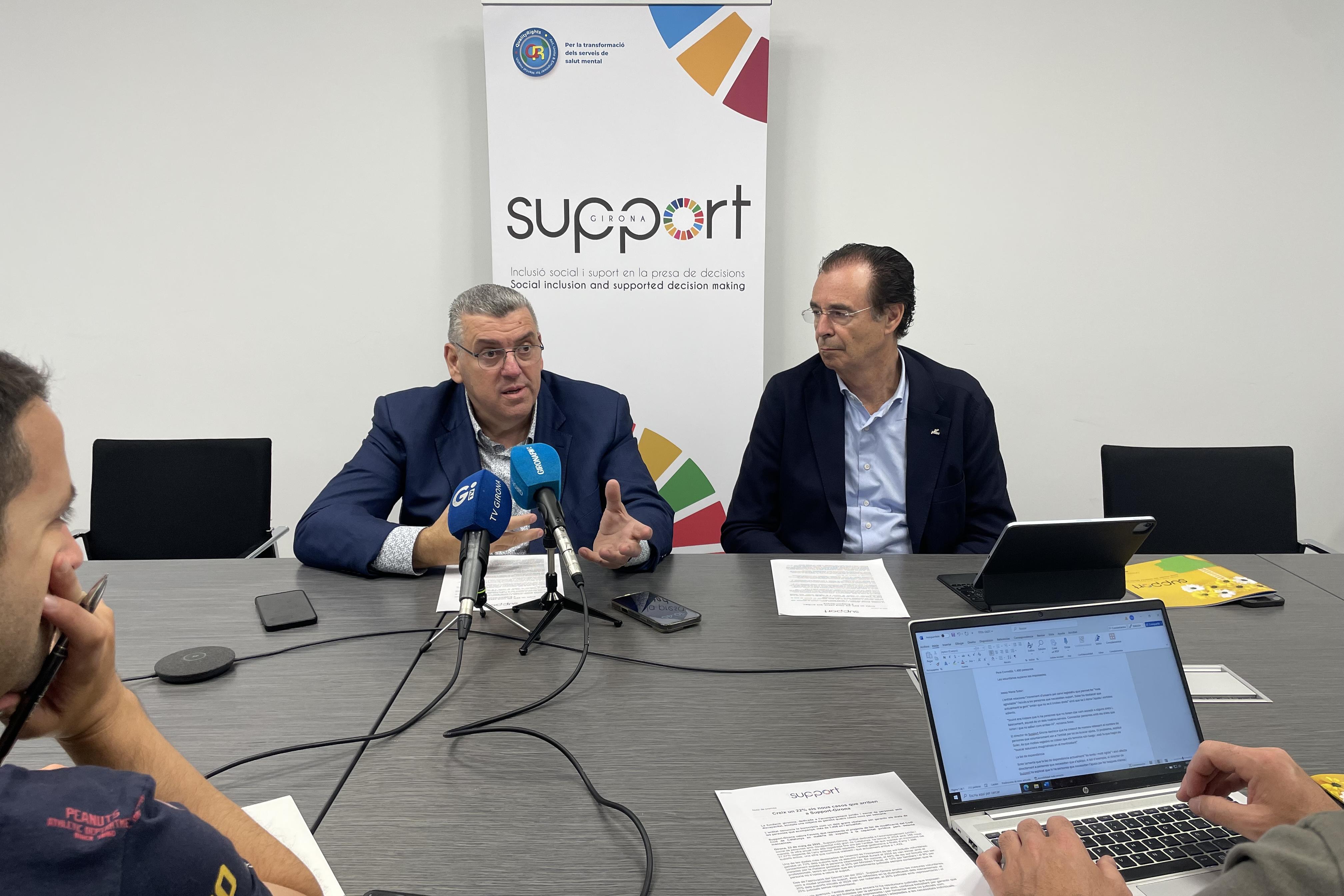 Dues persones davant micros informant en roda de premsa