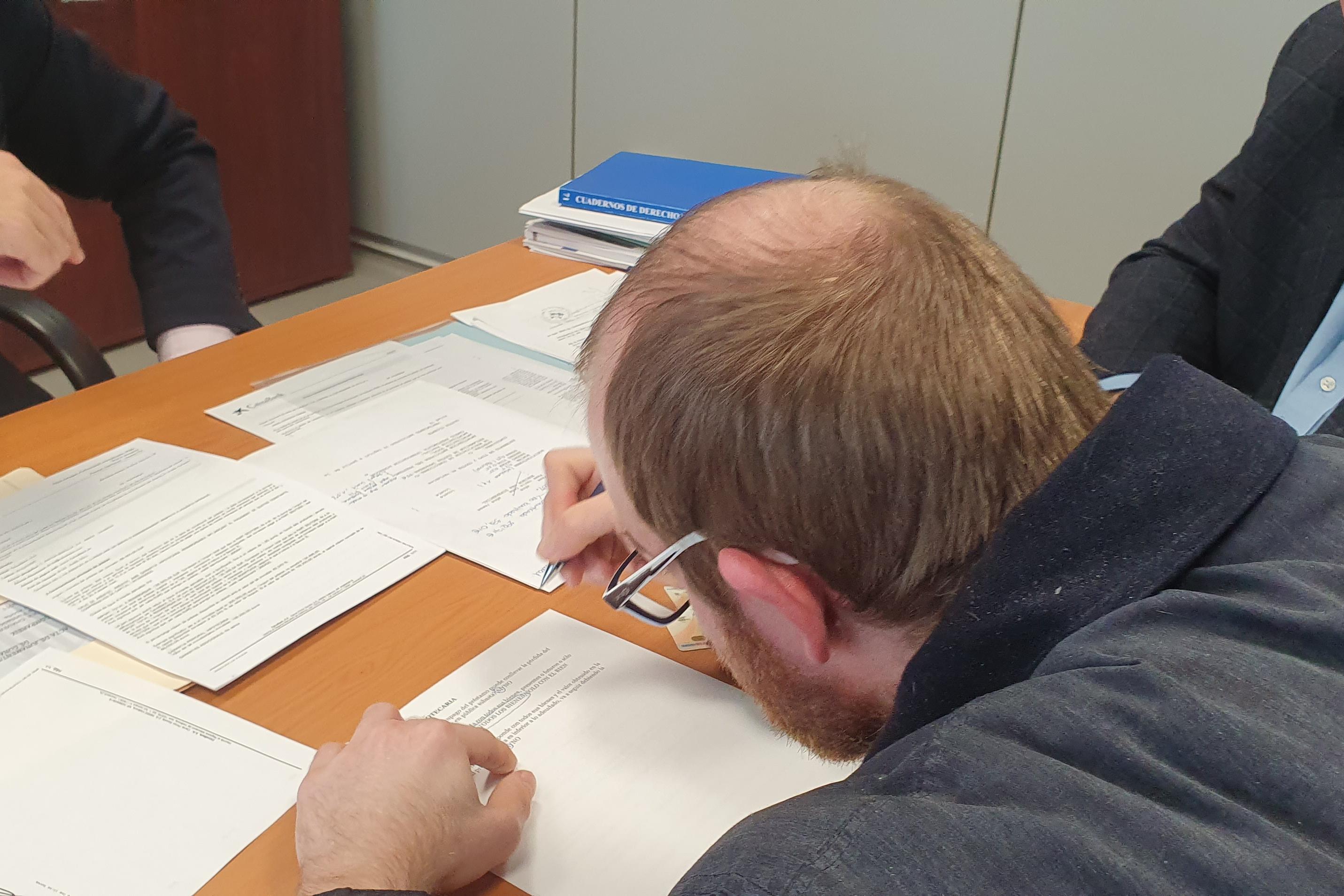 Una persona signant un document al notari